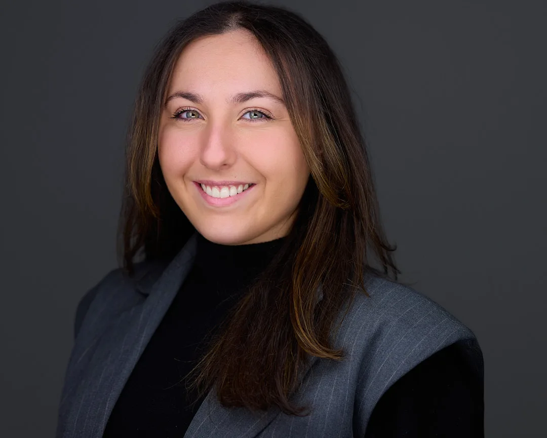 Professional headshot of a South Riding VA professional in a gray pinstripe vest and black turtleneck