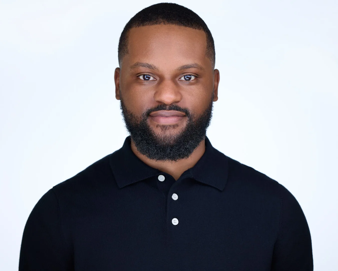 Professional headshot of an Ashburn VA professional in a black polo shirt on a light backdrop