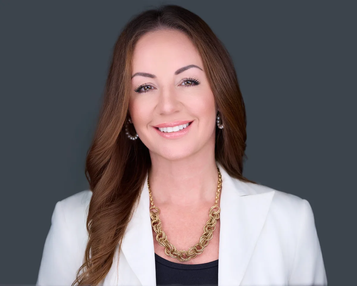 Realtor headshot of a Northern Virginia real estate agent in a white blazer, warm and credible