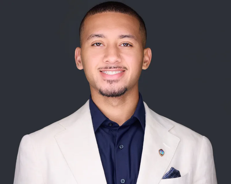 Headshot of a newer real estate agent, lit and cropped to match an existing brokerage roster